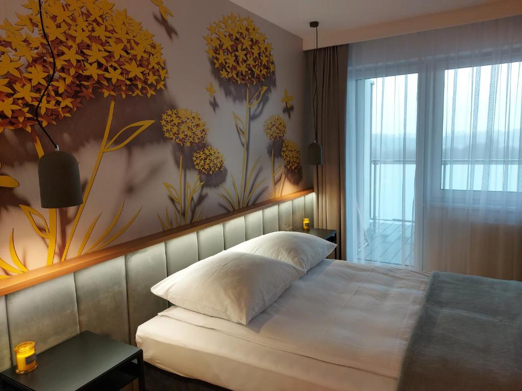 um quarto com uma cama com um mural de flores na parede em Patio Jazz em Koszalin