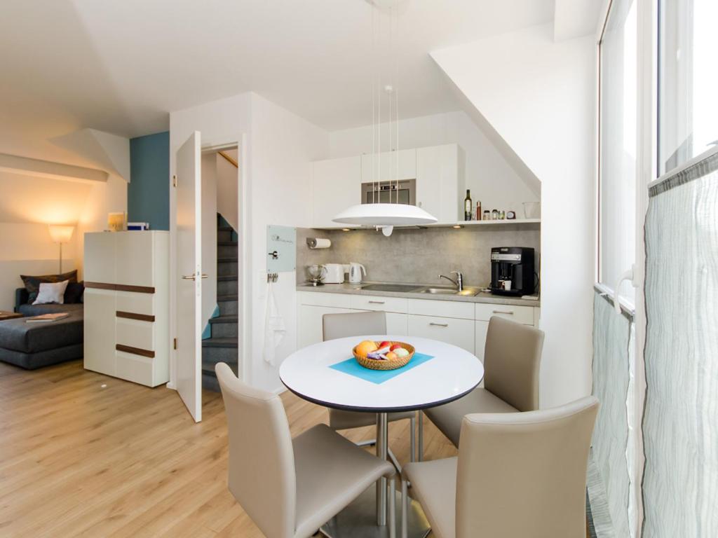 a kitchen and living room with a table and chairs at de Luxe Maisonette Dünenlicht in Norderney