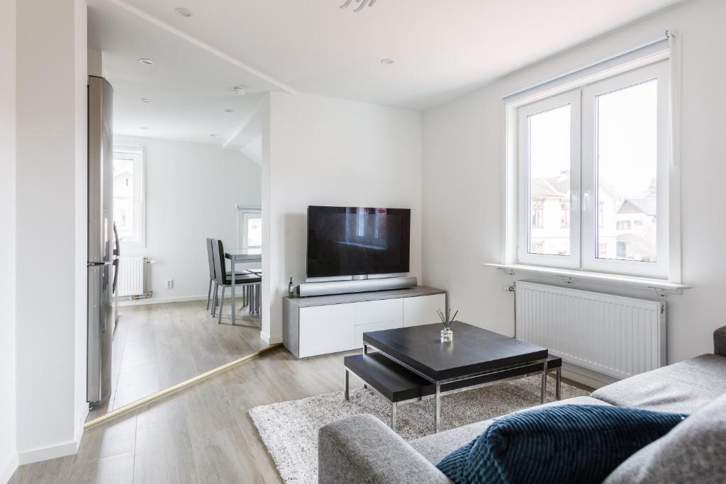 uma sala de estar com um sofá e uma televisão em Flores 3 em Jönköping