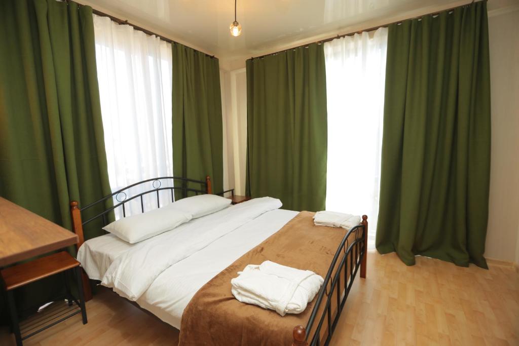 a bedroom with a large bed with green curtains at CHOGO in Kutaisi