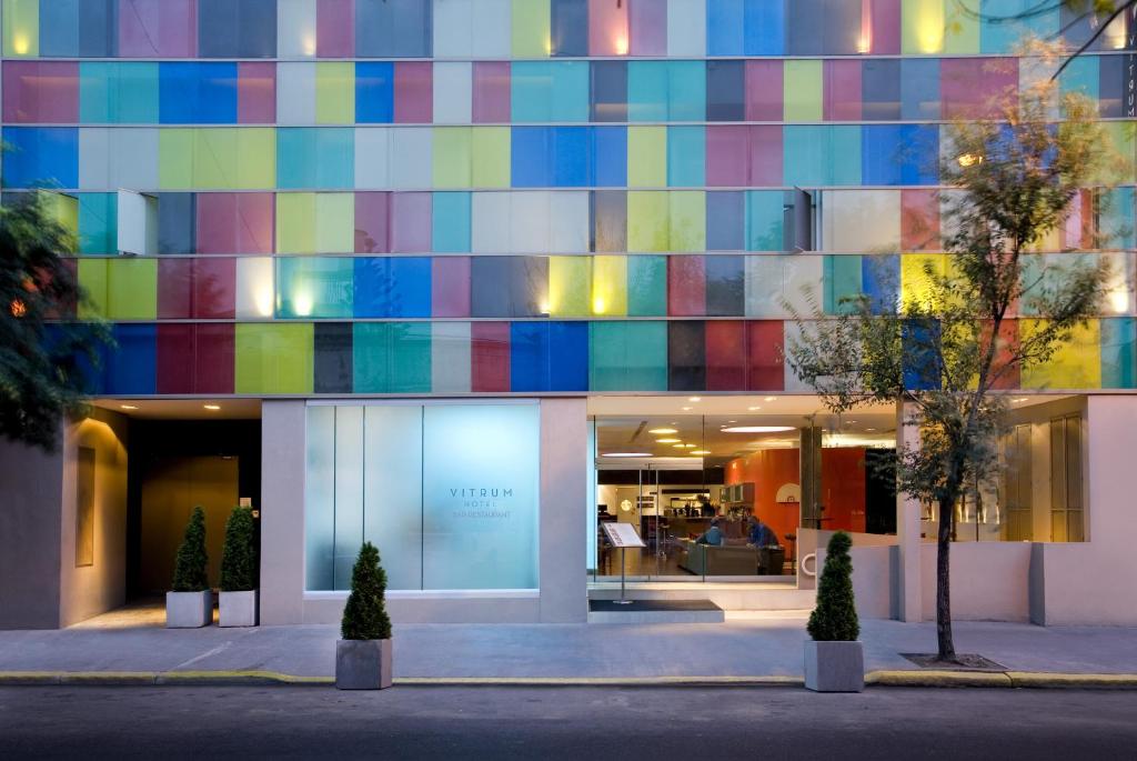 Boutique Suites Palermo في بوينس آيرس: مبنى بالواجهة الملونة مع الأشجار في الأمام