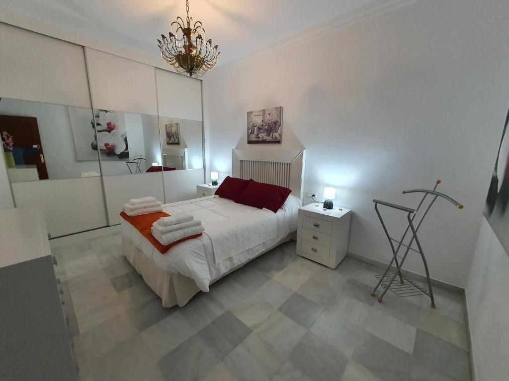 una camera bianca con letto e lampadario pendente di Piso tres dormitorios centro de Marchena. Sevilla a Marchena
