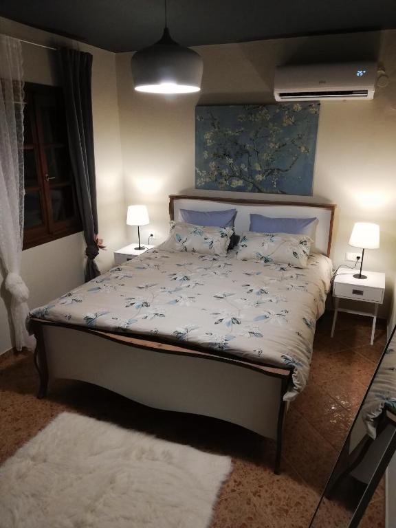 sypialnia z łóżkiem z dwoma stołami i dwoma lampami w obiekcie Endless View Country House w mieście Makrinítsa