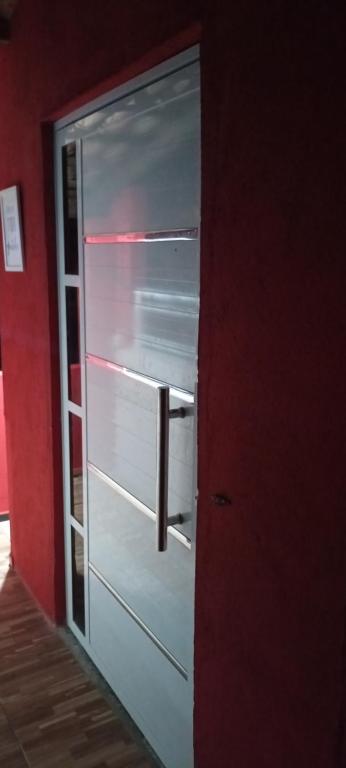 Casa Friozinho da serra في غواراميرانغا: باب الثلاجة مفتوح في غرفة حمراء
