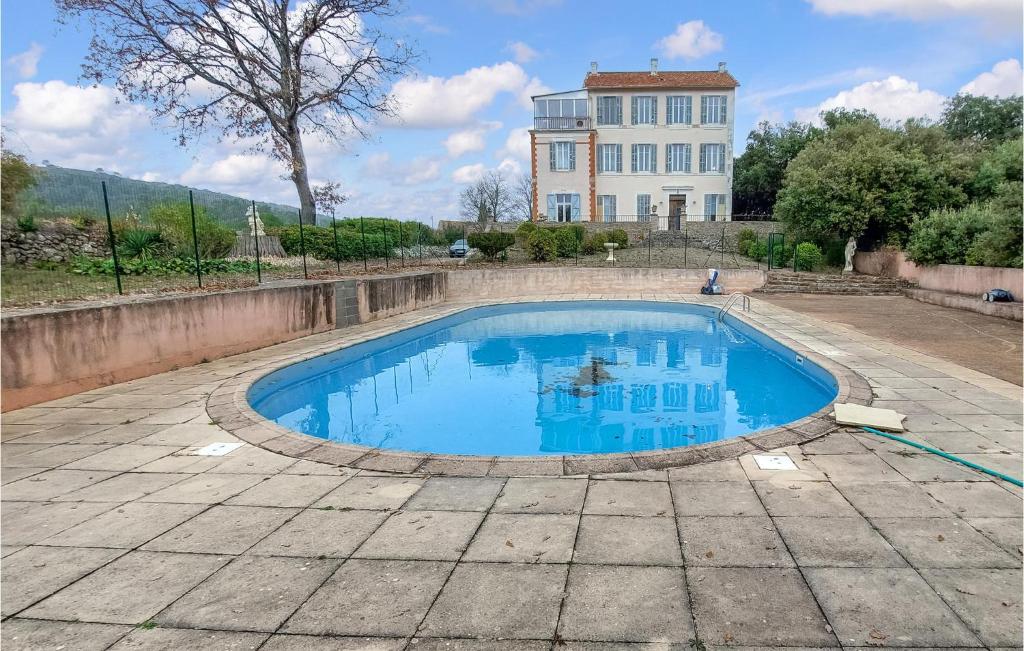 una piscina en un patio con un edificio en el fondo en 2 Bedroom Amazing Apartment In Fox Amphoux, en Fox-Amphoux
