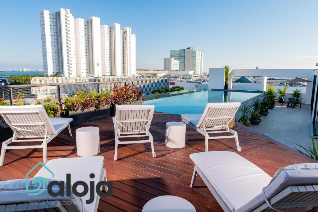 uma varanda com cadeiras e uma piscina num edifício em Torre Sofia magnific apartments & estudios with great amenities em Cancún