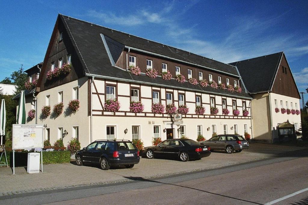 un grand bâtiment avec des voitures garées devant lui dans l'établissement Gasthof zum Fürstenthal, à Frauenstein