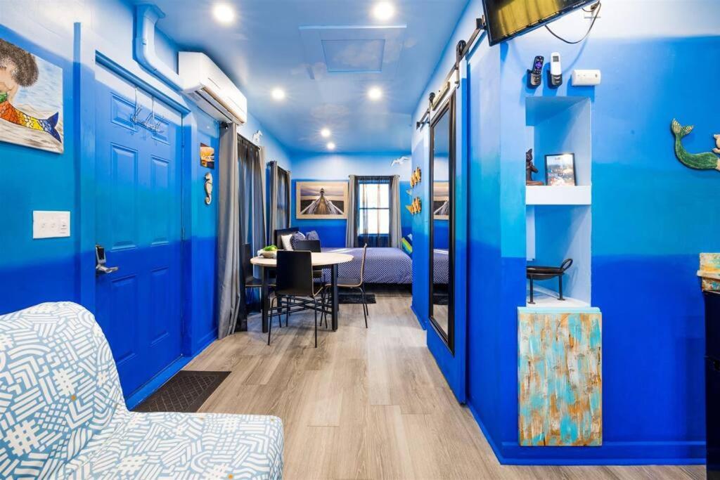 Habitación con paredes azules, mesa y sillas. en Whimsical Tiny House, Cape Charles Virginia, en Cape Charles
