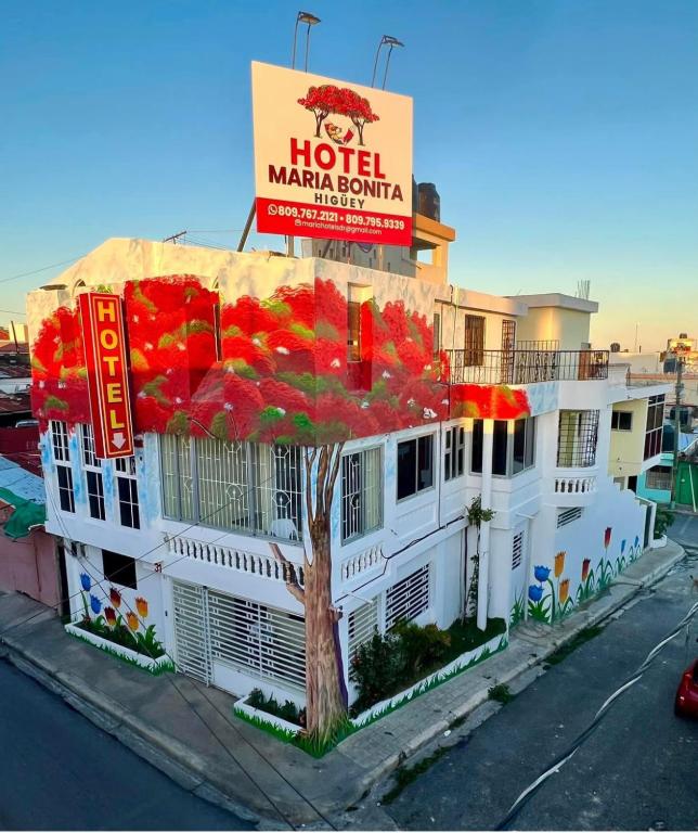 a hotel with a sign on top of a building at Hotel Maria Bonita Higüey in Higuey