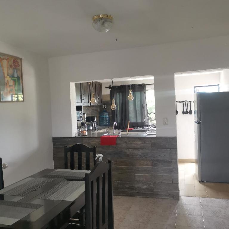 a kitchen with a dining table and a refrigerator at Casa marthita in Cozumel