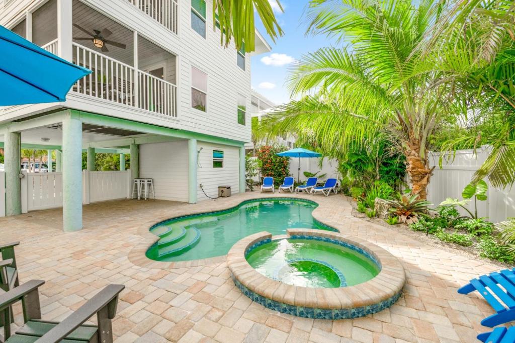 a pool in the backyard of a house with palm trees at Found Your Sol Mate Gorgeous Home w Pool Spa Steps to Bean Point Dogs OK in Anna Maria