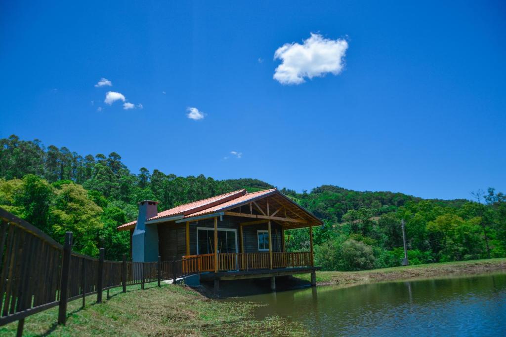 a small building on the side of a river at Refúgio das Uvas * Casa do Lago in Frederico Westphalen