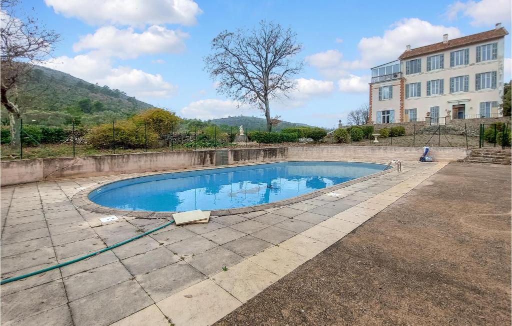 a swimming pool in a yard next to a building at Nice Apartment In Fox Amphoux With Outdoor Swimming Pool, 1 Bedrooms And Wifi in Fox-Amphoux