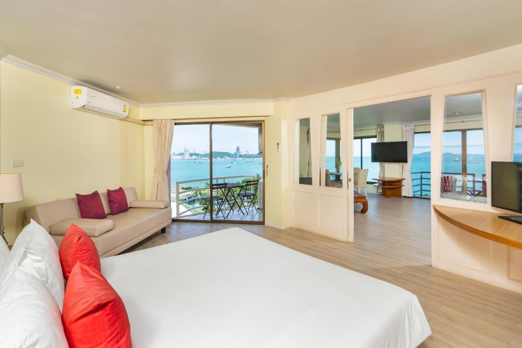 a hotel room with a bed and a view of the ocean at Bella Villa Metro in North Pattaya