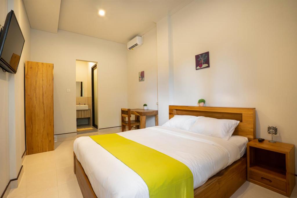 a bedroom with a large bed and a bathroom at K Hostel Seminyak in Seminyak