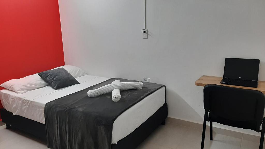 1 dormitorio con 1 cama con escritorio y ordenador portátil en PRIMAVERA LIVING, en Medellín