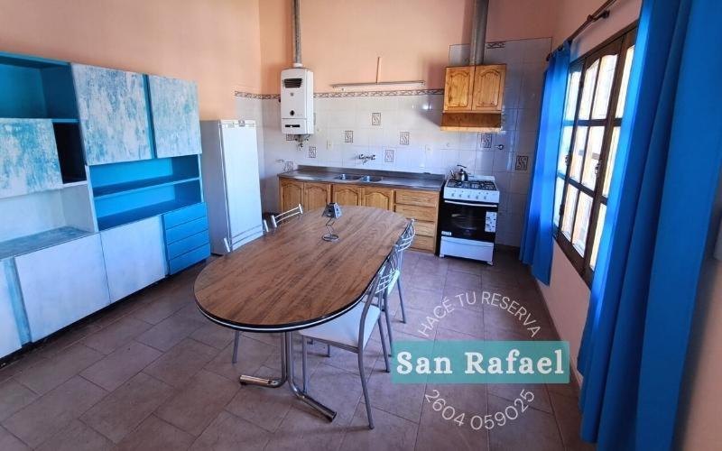 una cocina con una mesa de madera en el medio. en Departamento Céntrico en San Rafael