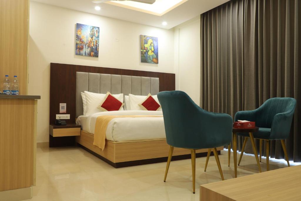 グルガオンにあるHotel Gurugramのベッド1台と椅子2脚が備わるホテルルームです。