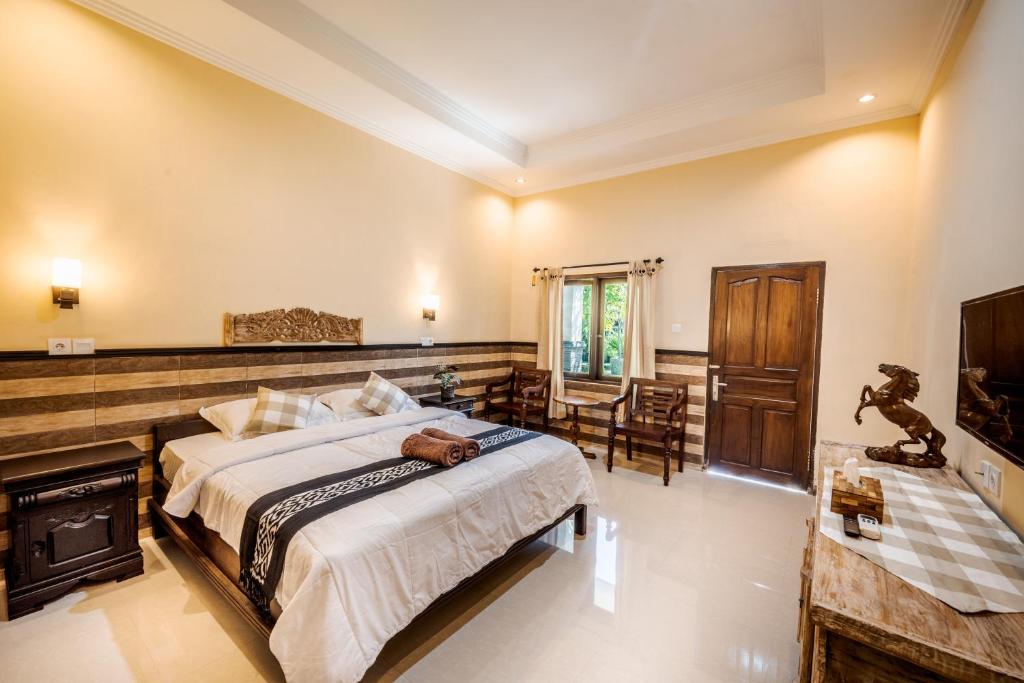 um quarto com uma cama grande e uma lareira em Gria Umasari Sanur em Sanur