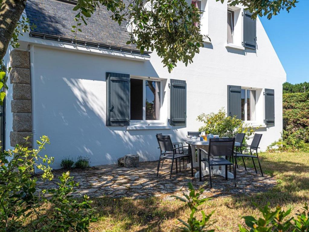 un patio avec une table et des chaises devant une maison dans l'établissement Villa néo-bretonne 5p, 120m², 8 pers, à 600m de la plage, jardin, Wifi, animaux acceptés, 3* - FR-1-477-6, à La Trinité-sur-Mer