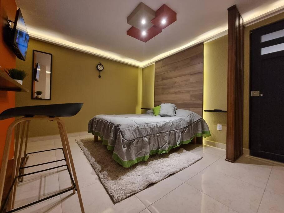a bedroom with a bed and a chair in it at Departamentos fresno! Tu mejor opción in Toluca