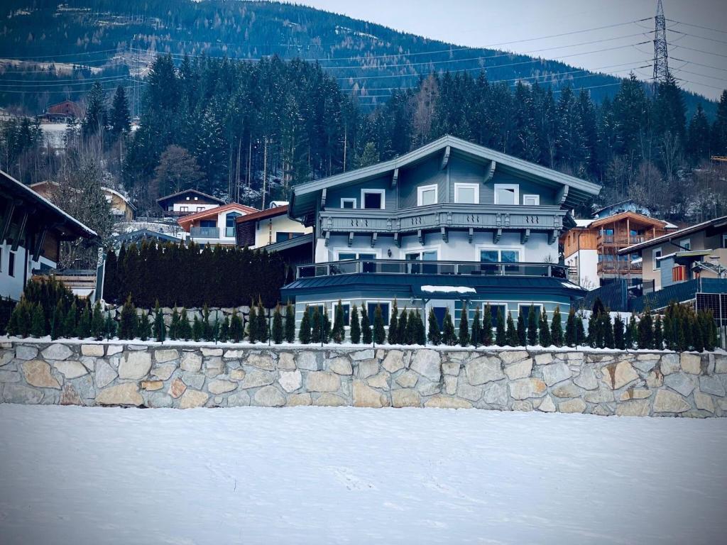 a large blue house on top of a stone wall at Apartment close to the ski area in Wald im Pinzgau