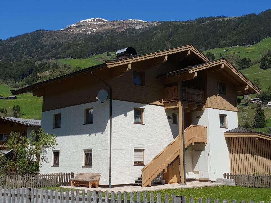 a large white house with a brown roof at Cozy apartment in Wald im Pinzgau with balcony and barbecue area in Wald im Pinzgau