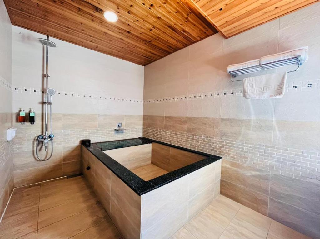 a bathroom with a bath tub with a shower at Kenting Summerland Garden Resort in Eluan