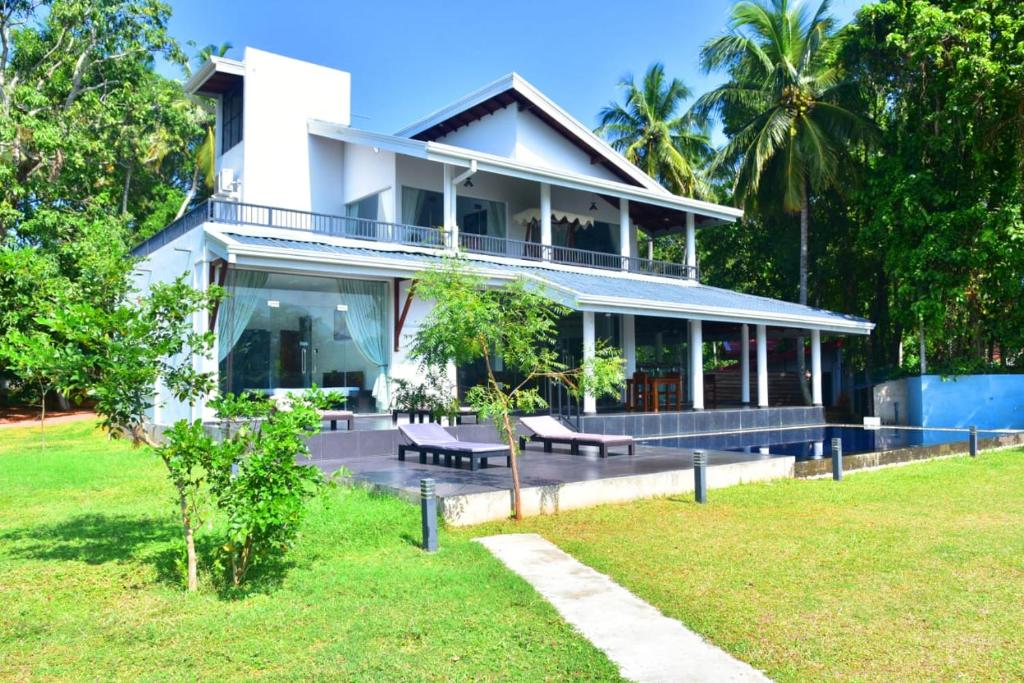 ein großes weißes Haus mit Rasen davor in der Unterkunft MARGOSA MOUNTAIN VILLA in Galewela