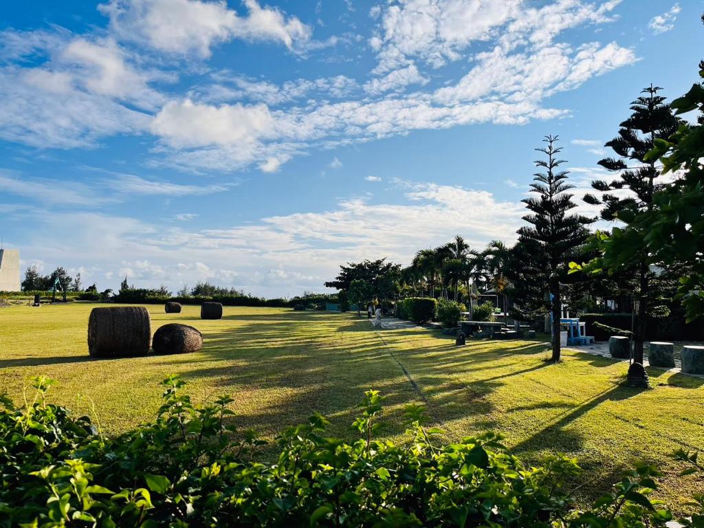 a grassy field with hay bales on it at Kenting Summerland Garden Resort in Eluan