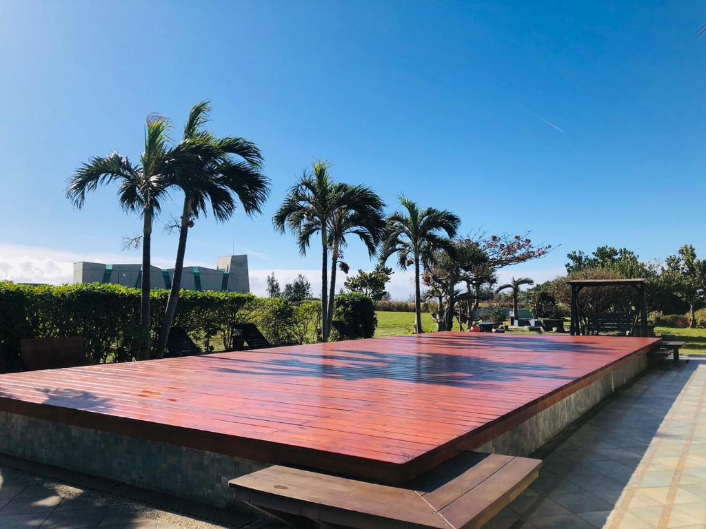 a large wooden table with palm trees in a park at Kenting Summerland Garden Resort in Eluan