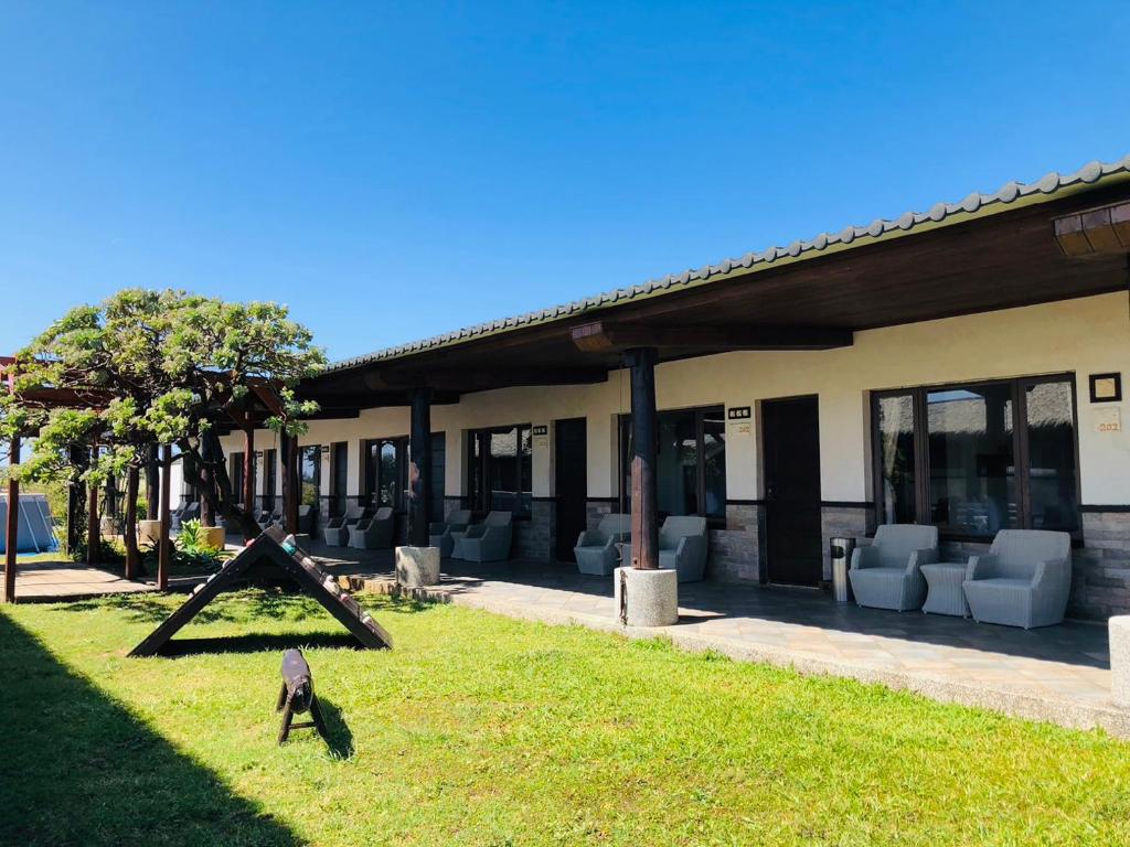 a bird standing in the grass in front of a building at Kenting Summerland Garden Resort in Eluan