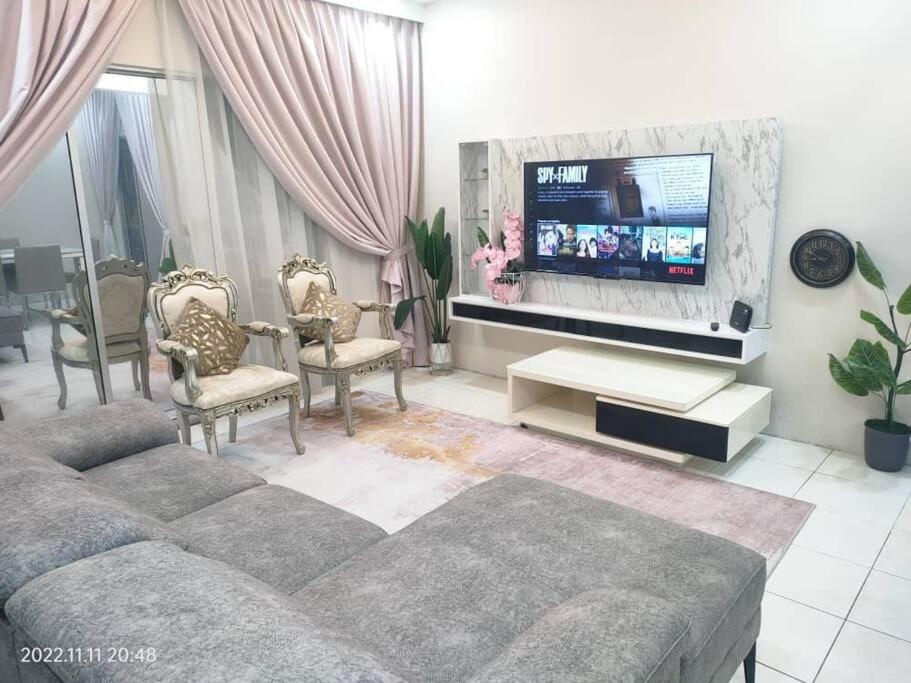 un soggiorno con divano e TV a schermo piatto di Embun Bayu Musliim homestay a Rawang