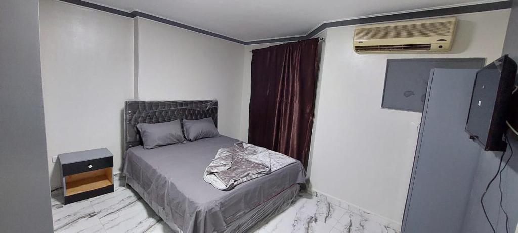 Best Dreams Hotel في القاهرة: غرفة نوم صغيرة بها سرير ومكيف