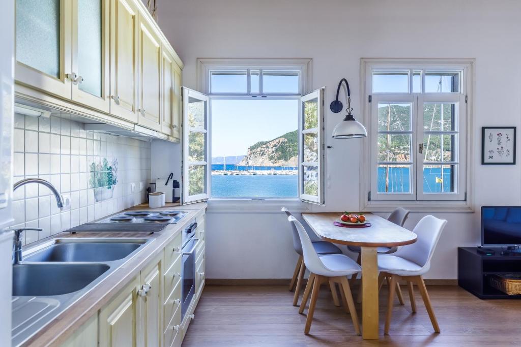 a kitchen with a table and chairs and a window at Vivere Skopelos in Skopelos Town