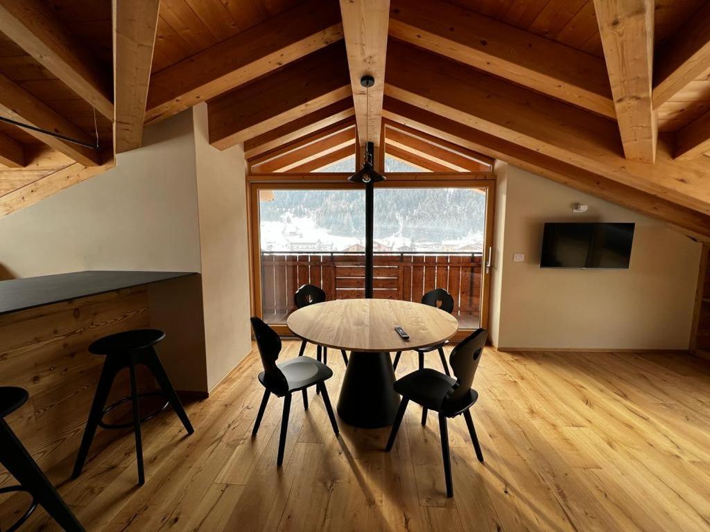 a table and chairs in a room with a large window at YETI Design mountain apartments in Valdidentro