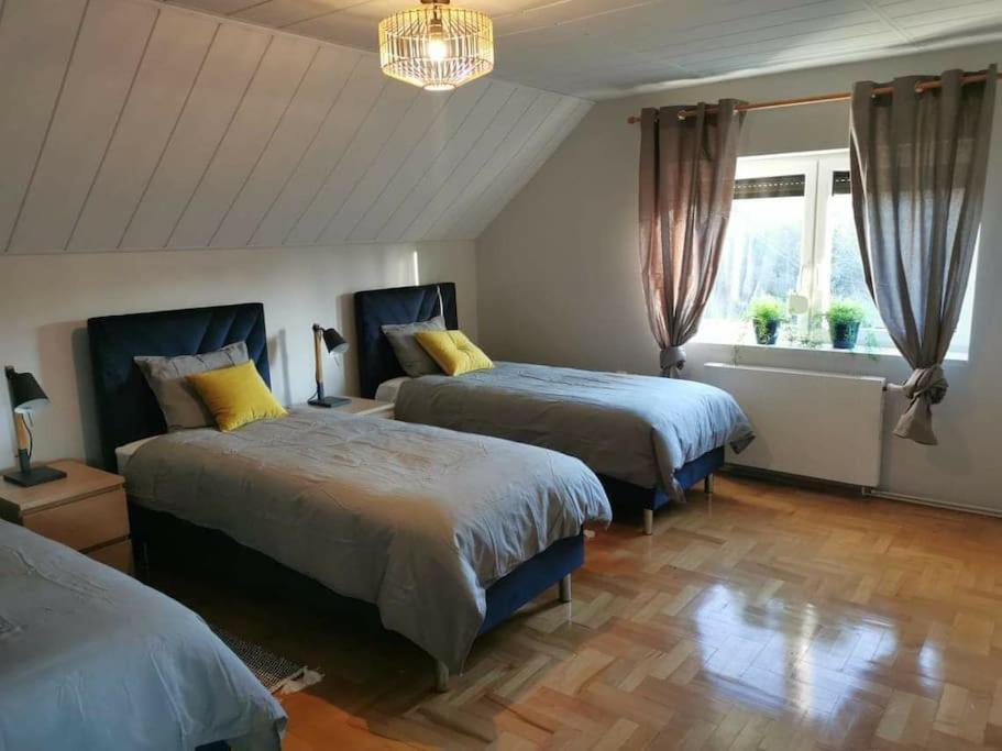 1 dormitorio con 2 camas y lámpara de araña en Klimatyczny dom w Wąchocku, en Wąchock