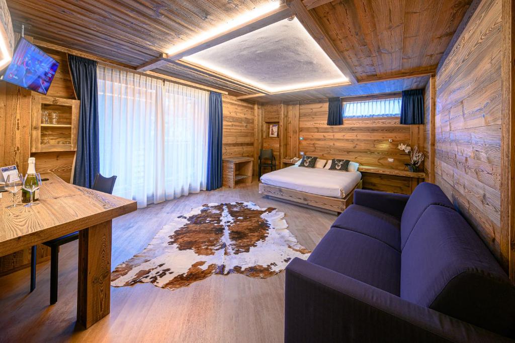 een slaapkamer met een bank en een bed in een kamer bij Hotel Ambrosini in Aprica