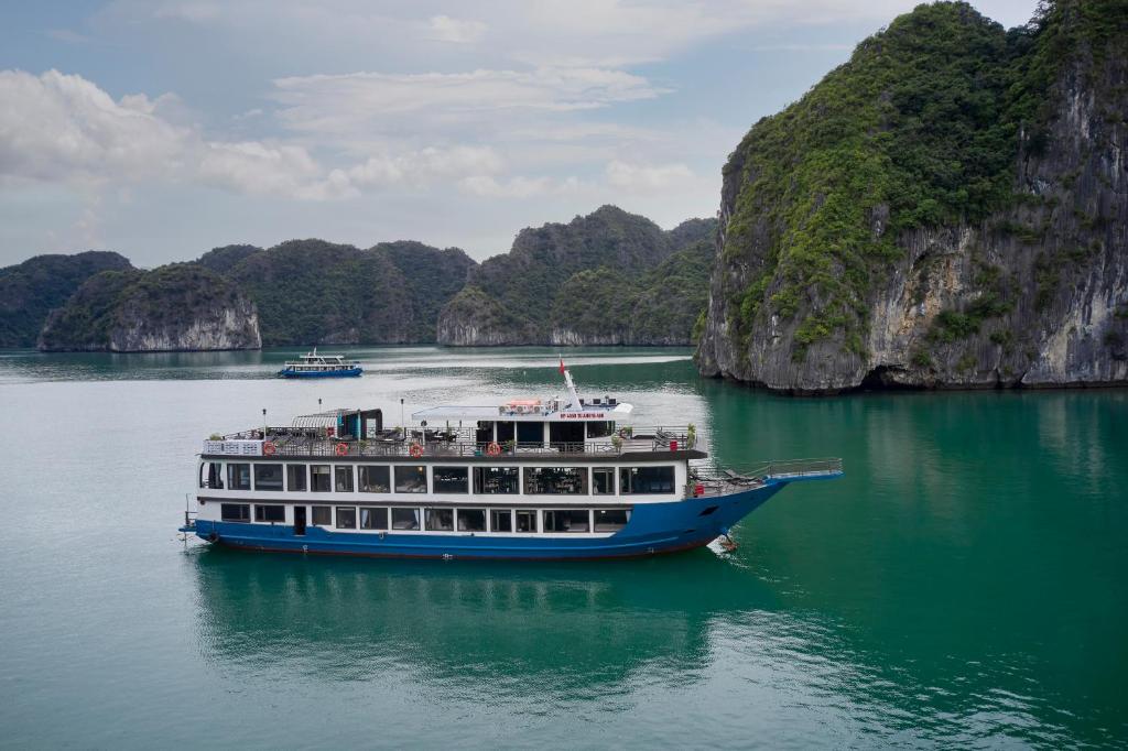 a boat in a body of water with mountains at La Pandora Boutique Cruises in Ha Long