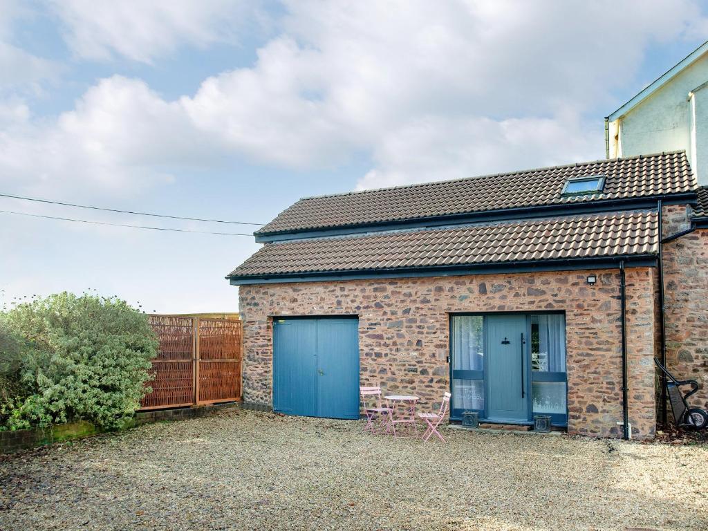 a brick building with two blue garage doors at The Cow Shack in Cadeleigh