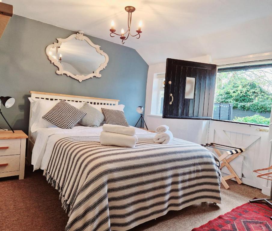 1 dormitorio con 1 cama con espejo en la pared en The Jolly Sailor, Orford en Orford