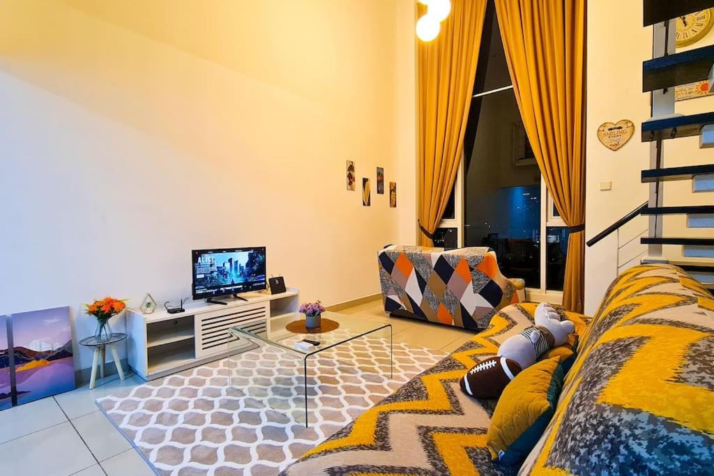 a living room with a couch and a tv at Elegant 5STAR Resort Suite Mid Valley KL Sunway by Stayz Suites with Shopping Complex in Kuala Lumpur