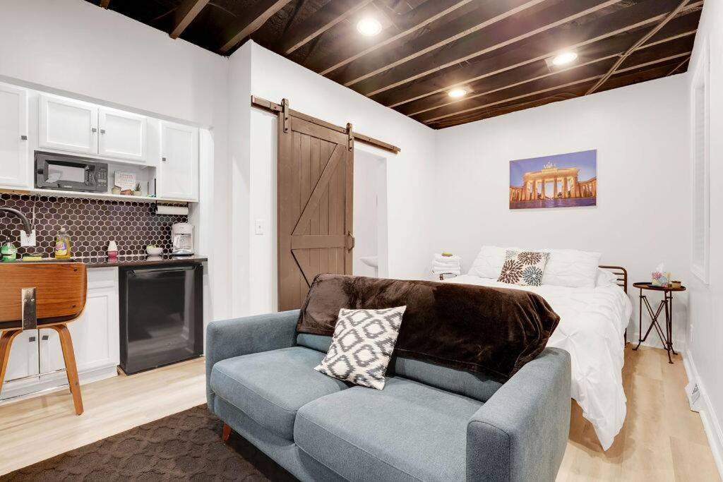 a bedroom with a bed and a couch and a kitchen at Housepitality - The Brandenburg Suite - Efficiency in Columbus