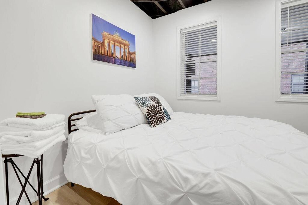 Dormitorio blanco con cama blanca y mesa en Housepitality - The Brandenburg Suite - Efficiency, en Columbus