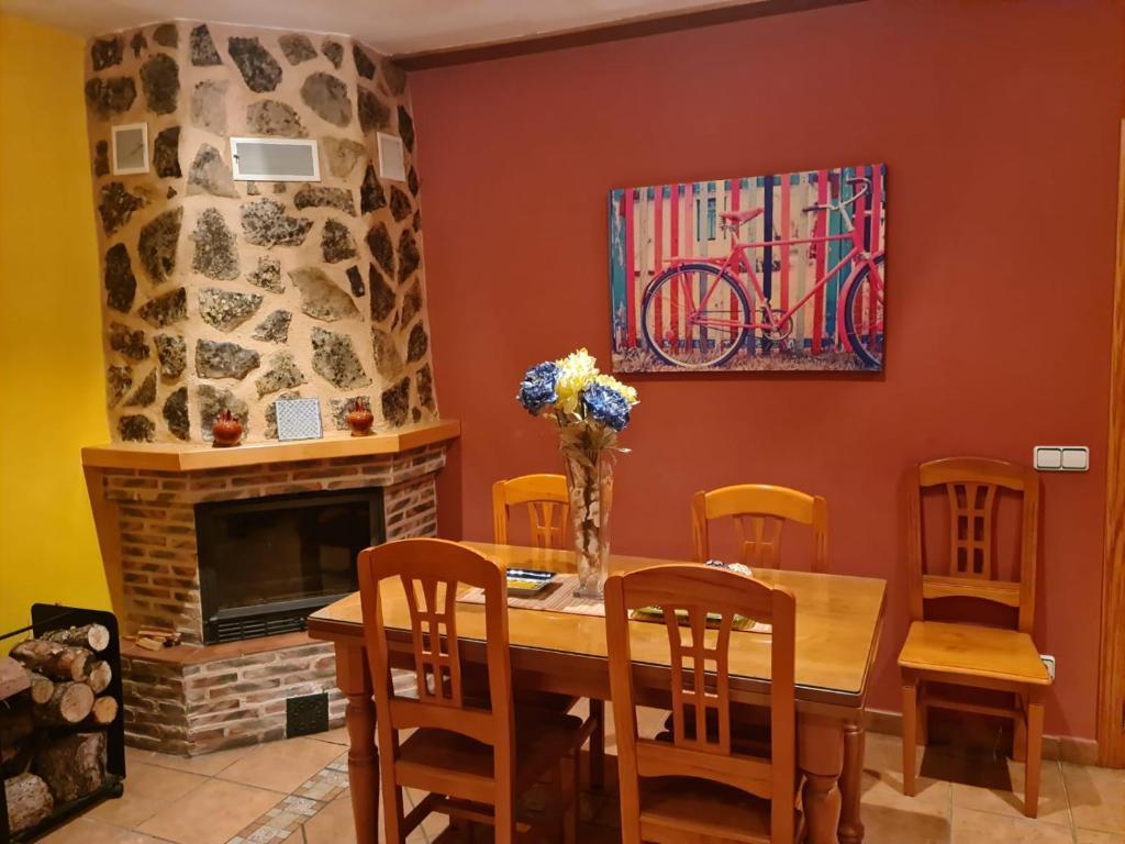 comedor con mesa, sillas y chimenea en Alojamientos Carmen, en Beteta