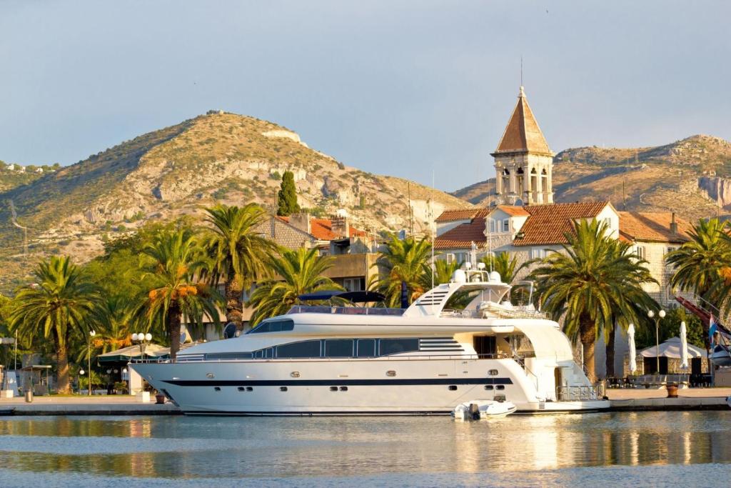 un yacht blanc dans l'eau en face d'une ville dans l'établissement Apartment in Okrug Gornji with sea view, terrace, air conditioning, WiFi 5069-3, à Trogir