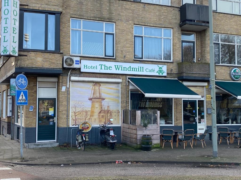 een gebouw met een bord waarop staat gastheer van het windmolen café bij Hotel Cafe The Windmill in Schiedam