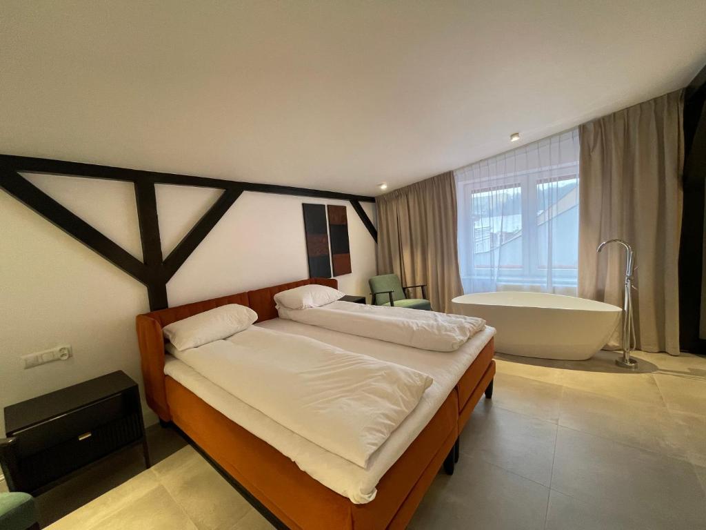 - une chambre avec un grand lit et une baignoire dans l'établissement Apartamenty Jezuicka 16, à Bydgoszcz