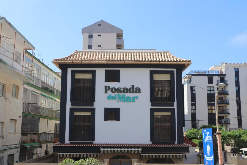 a building with a sign that reads pococi all war at 101 I Posada del Mar I Encantador hostel en la playa de Gandia in Playa de Gandia