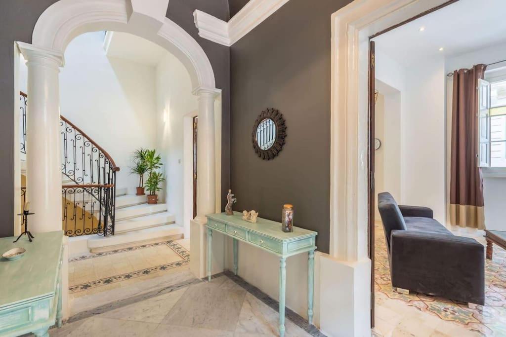 a living room with a table and a staircase at Spacious 4-Bedrooms Townhouse in Tas-Sliema in Sliema
